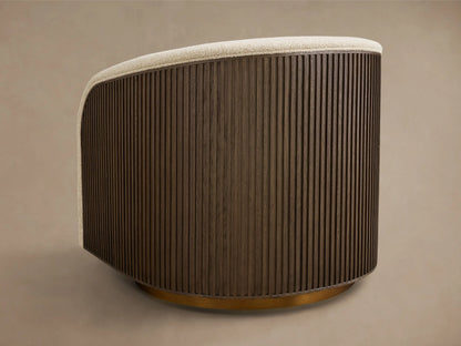 Side profile of the Finnley Swivel Chair with dark ribbed wood back, cream upholstery, and a brass swivel base.