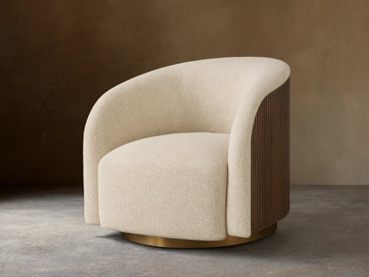 Cream Finnley Swivel Chair with curved, textured upholstery, dark brown vertical wood slats on the side, and a golden swivel base.