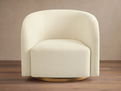 Angled view of an off-white upholstered Finnley Swivel Chair™ with a dark wood slatted curved back.