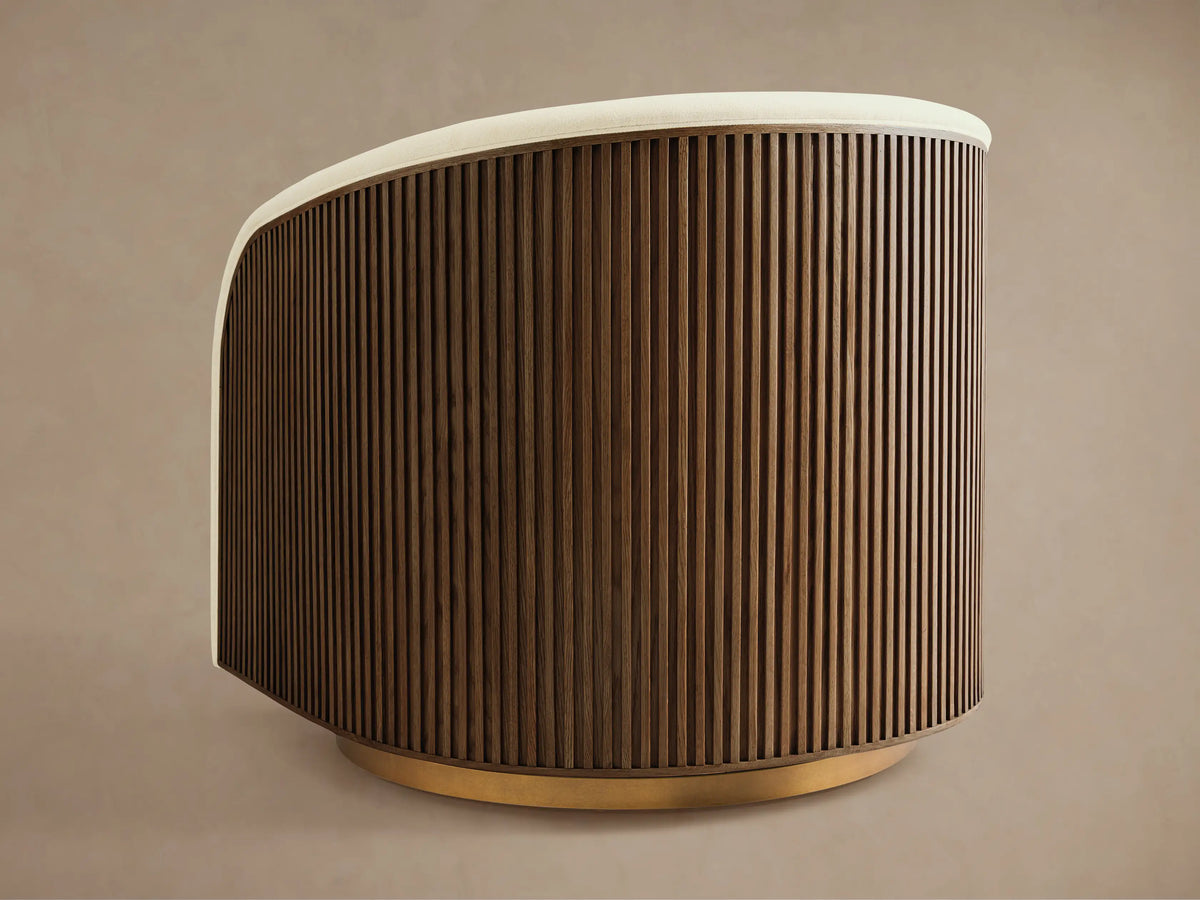 Finnley Swivel Chair in side view, featuring a curved back with vertical wood slats, beige seat, and a gold swivel base.