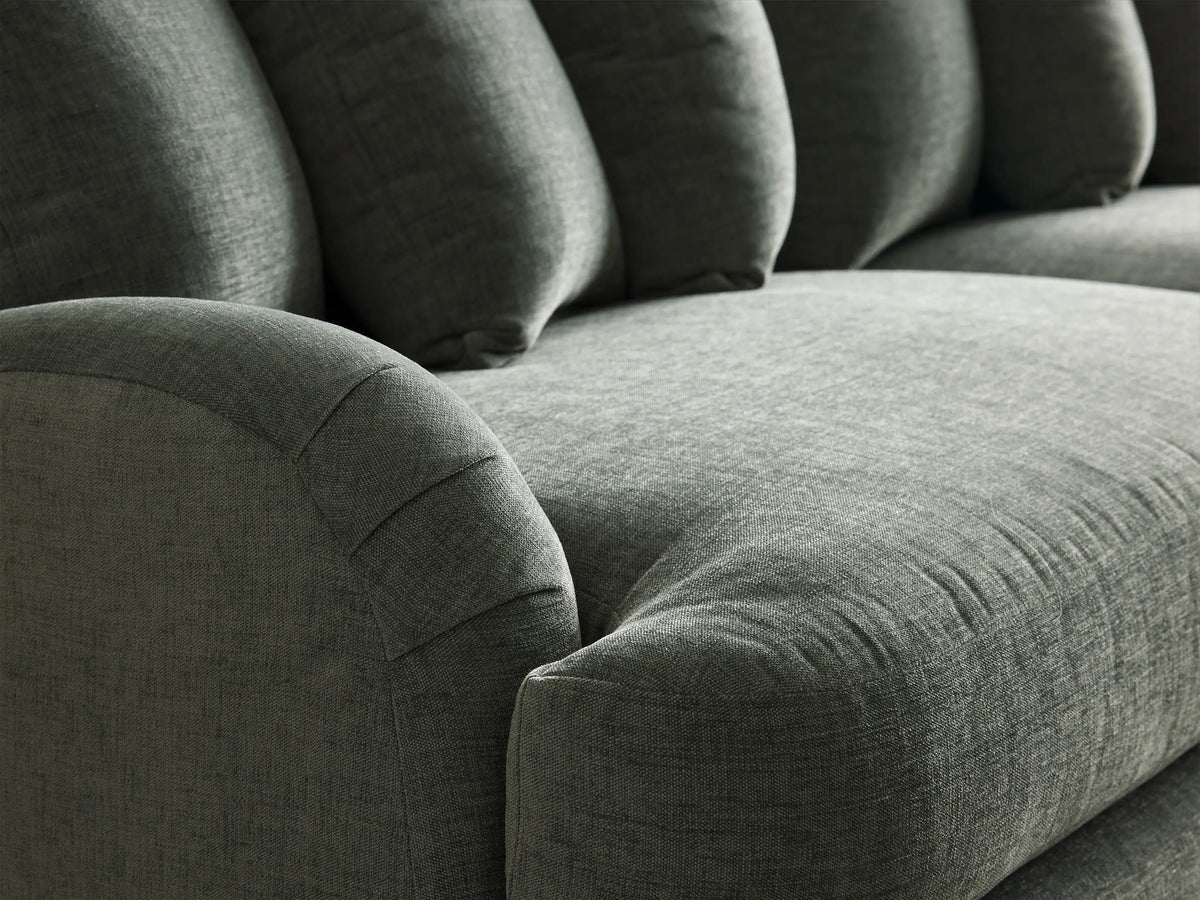 Angled Hanover Sofa in textured dark green fabric with rolled arms, five plush back cushions, and tapered wood legs.
