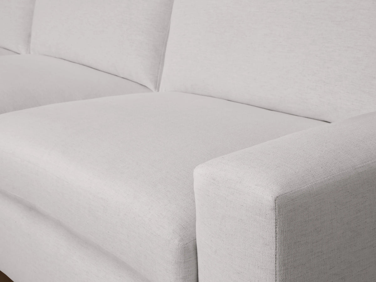 Kipton Wide Arm Two-Piece Chaise Sectional in light grey fabric, featuring a wide armrest and plush seat cushions, viewed from a side angle.
