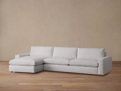 Kipton Wide Arm Two-Piece Chaise Sectional in light gray fabric, featuring wide arms, plush cushions, and left-facing chaise.