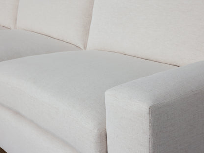 Wide arm of the Kipton sectional in off-white fabric, showing smooth texture and plush seating against matching backrest.