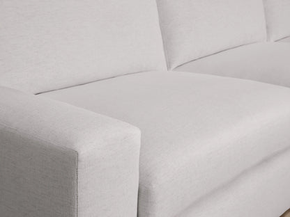 Kipton sectional close-up showing a light gray fabric with wide armrests, plush seat and back cushions, illustrating its soft texture.