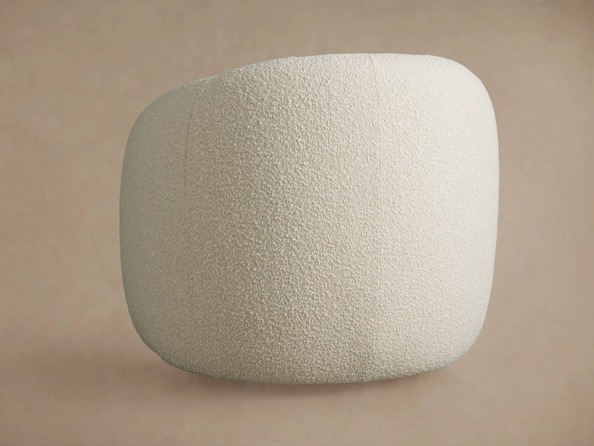 Close-up of Fresno Swivel Chair's light cream textured bouclé fabric, highlighting the curved arm and seat.