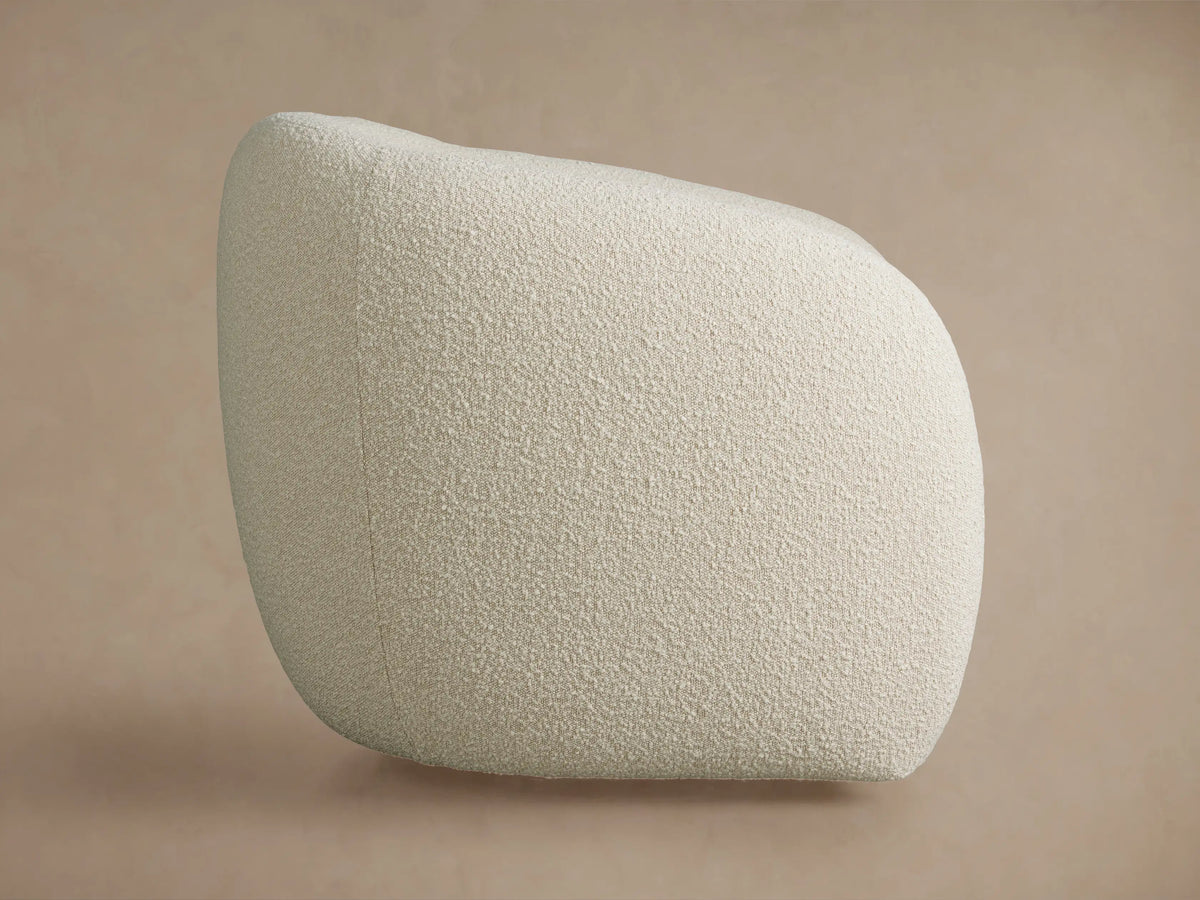 Fresno Swivel Chair in light cream boucle fabric, rounded shape, centered against a plain beige wall.