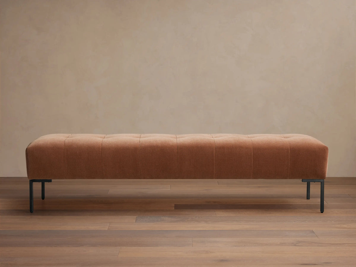 Tilton Tufted Bench, long muted terracotta tufted upholstered bench with minimalist black metal legs on wood floor.