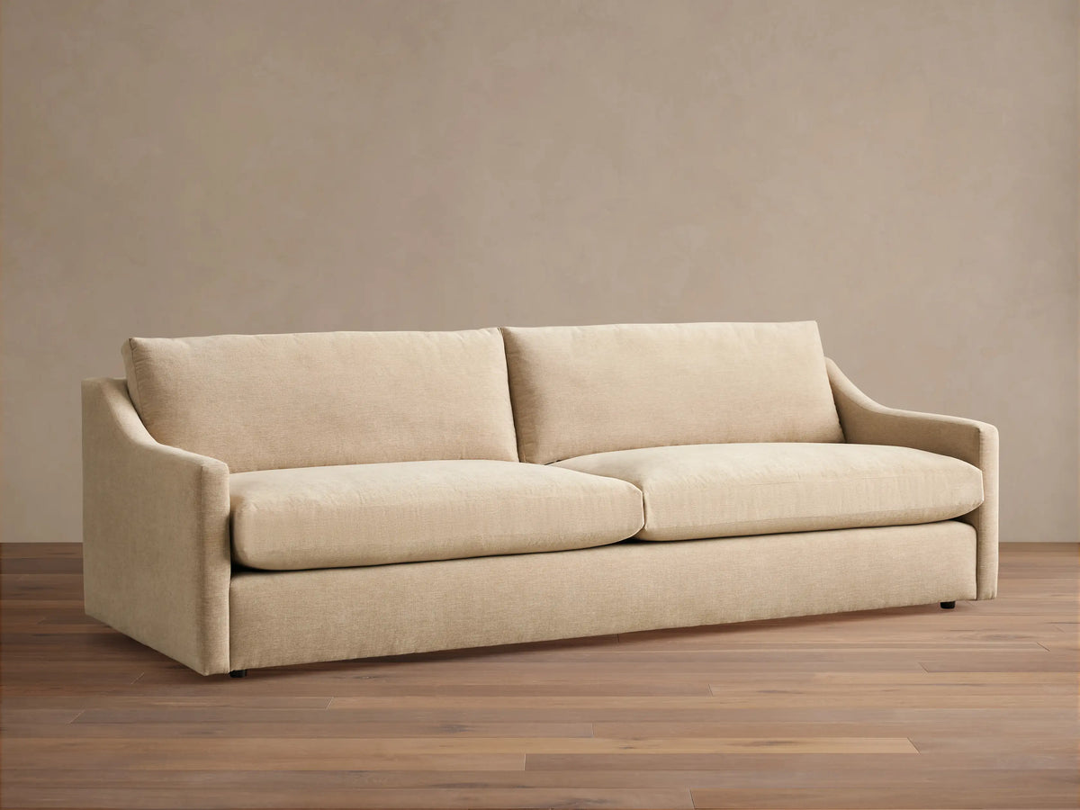 Front view of the gray plaid Kipton Slope Arm Sofa with throw pillows and a blanket in a stylish living room setting.