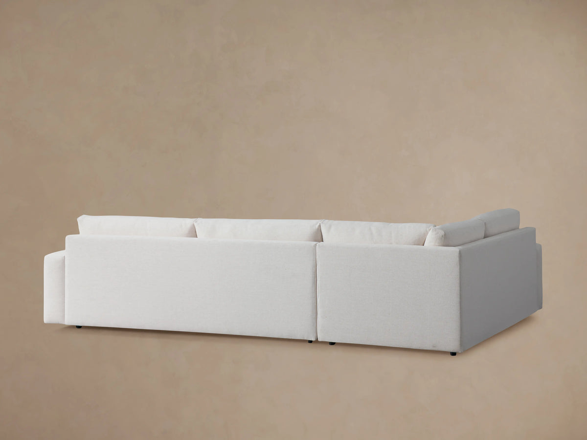 Kipton Wide Arm Two-Piece Sectional in light beige fabric, featuring wide armrests and plush seating, close-up view.