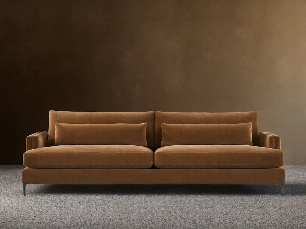 Sumner Sofa: Large, camel-colored velvet sofa with two seat cushions, two back cushions, and two lumbar pillows, on a wood floor.