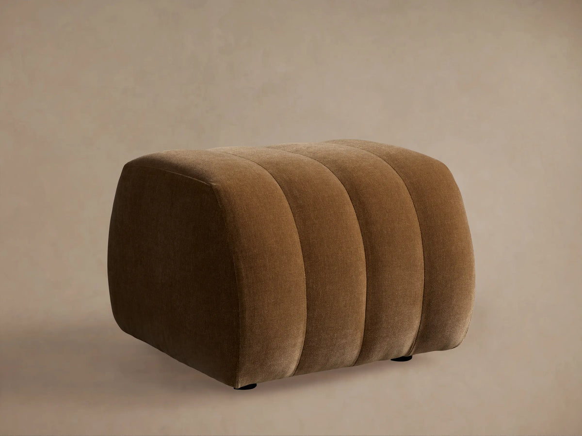 Close-up of the Fresno Channel-Stitched Ottoman in a rich brown fabric, highlighting its elegant curved channel stitching.