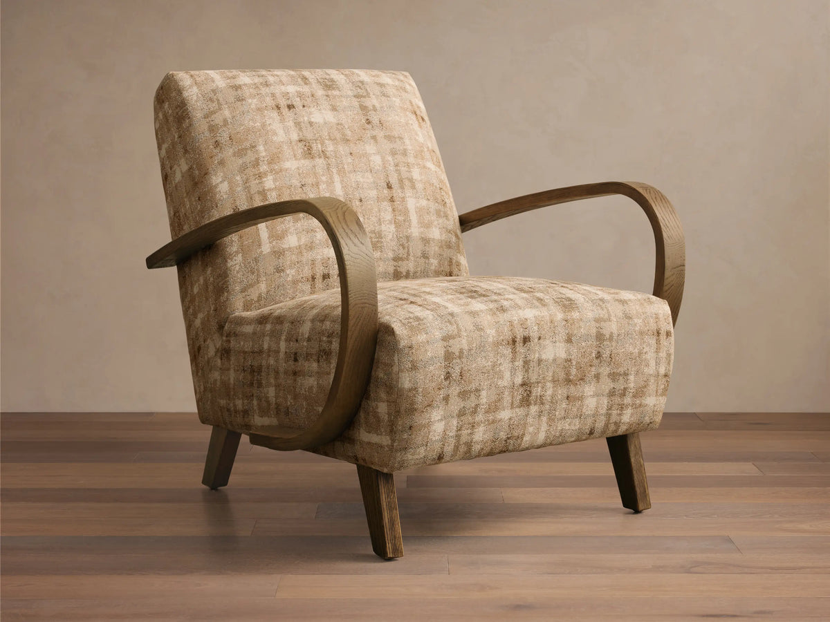 Front view of Gabel Chair, upholstered in beige and brown plaid fabric, with curved light wood armrests and tapered legs.