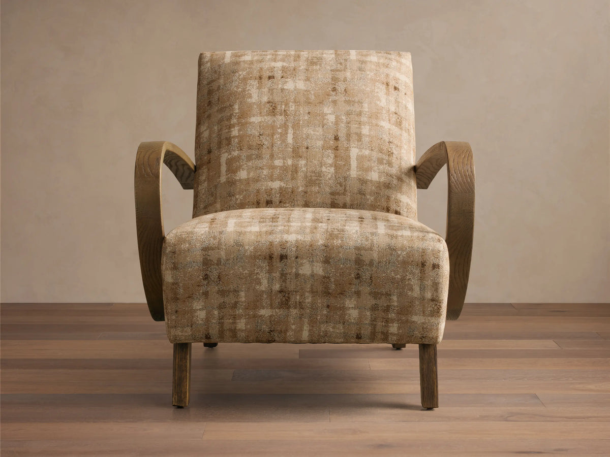 Front view of Gabel Chair, upholstered in beige and brown plaid fabric, with curved light wood armrests and tapered legs.