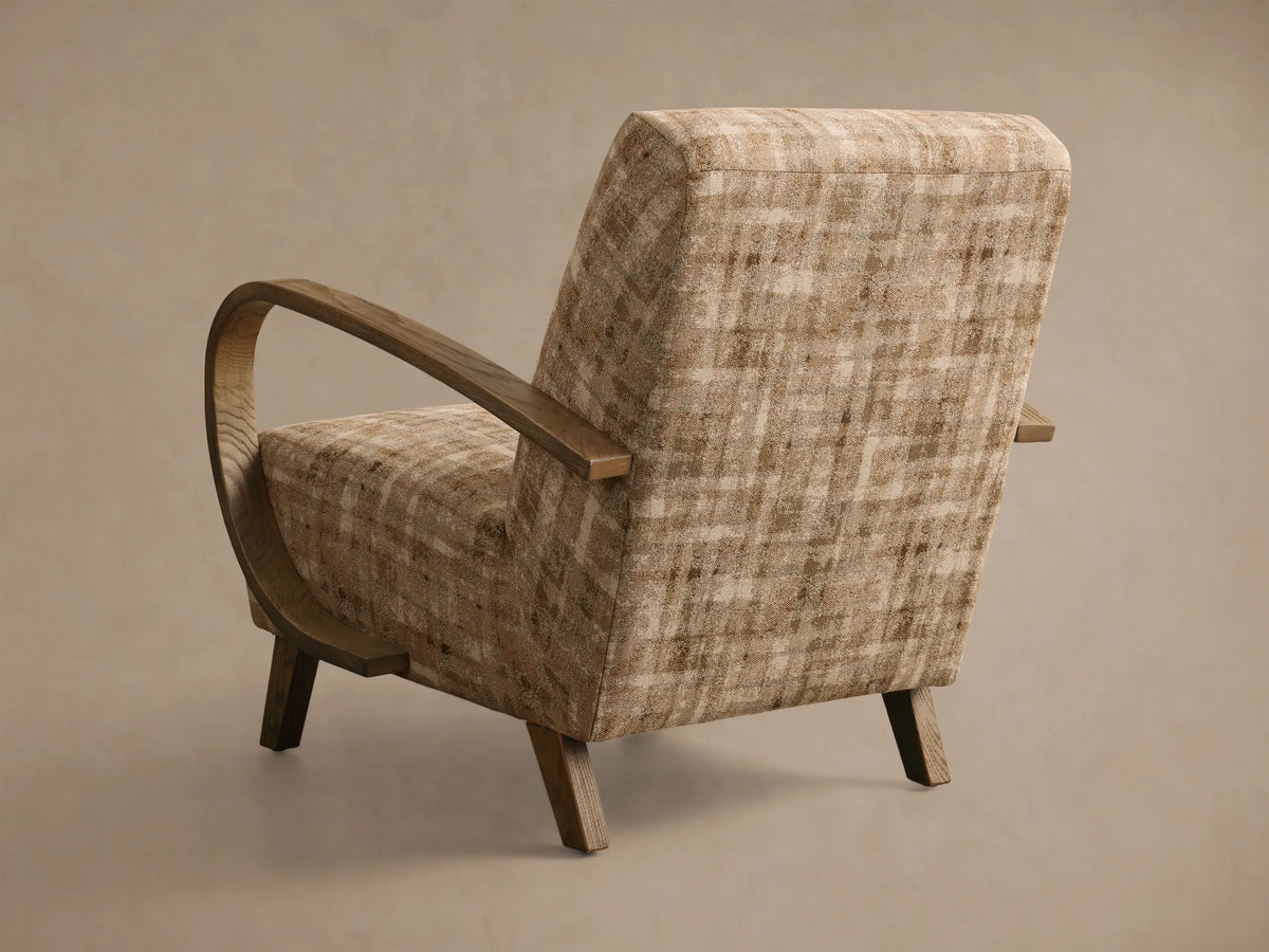 Close-up of the Gabel Chair, showing beige, cream, and brown abstract upholstered fabric and curved light brown wooden armrests.