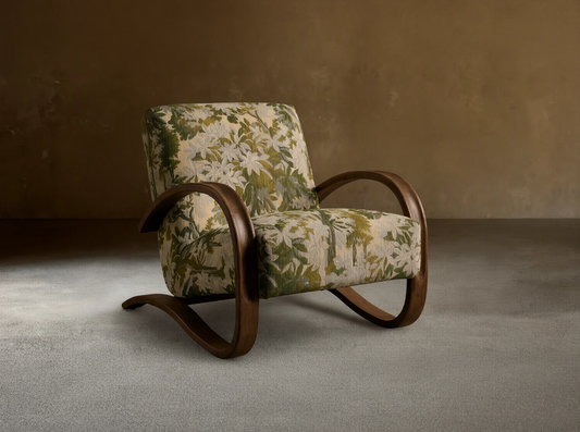 Allora Chair with a distinctive curved mocha wood frame & green, cream, and beige floral patterned upholstery on a wooden floor.