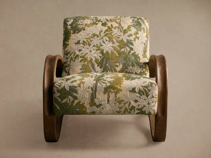 Allora Chair with a distinctive curved mocha wood frame & green, cream, and beige floral patterned upholstery on a wooden floor.