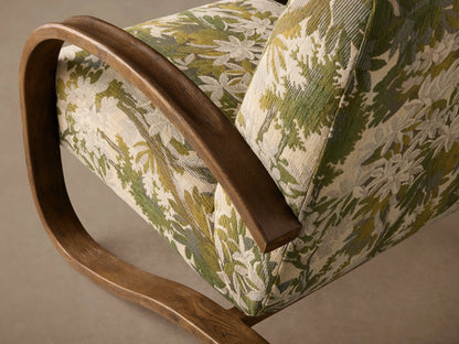 Allora Chair with a green, white & cream foliage upholstered seat/back, framed by curved dark mocha wood arms.