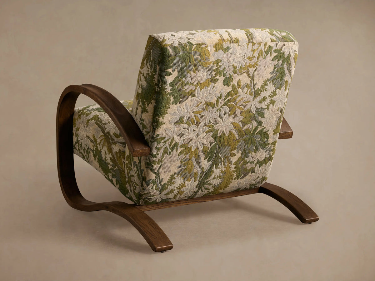 Allora Chair close-up. Curved red oak frame in mocha finish. Upholstery features green and white floral pattern.