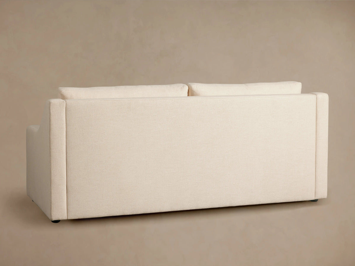 Ashby Luxury Sleeper Sofa in beige fabric, profile view, showing partially pulled-out mattress with quilted pattern, on a neutral background.