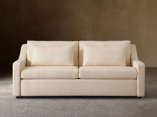 Ashby Luxury Sleeper Sofa in a light cream fabric, featuring plush cushions and clean lines, set against a neutral background.