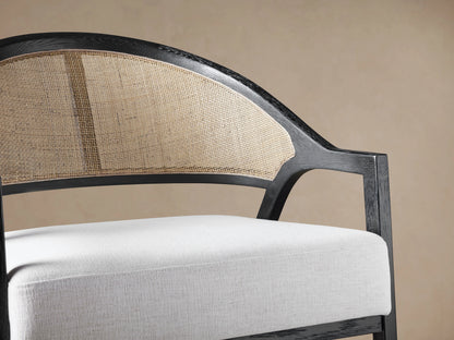 Aimee Chair in Nomad Snow, front view. Dark oak frame, curved cane rattan back, white fabric seat cushion.