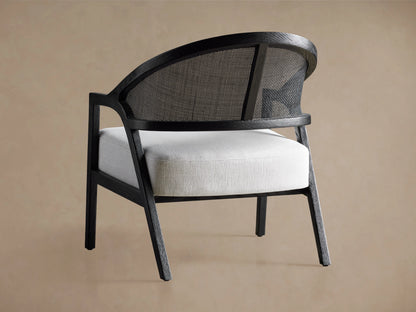 Close-up of Aimee Chair: dark oak frame with curved rattan back, and white Nomad Snow upholstered seat cushion.