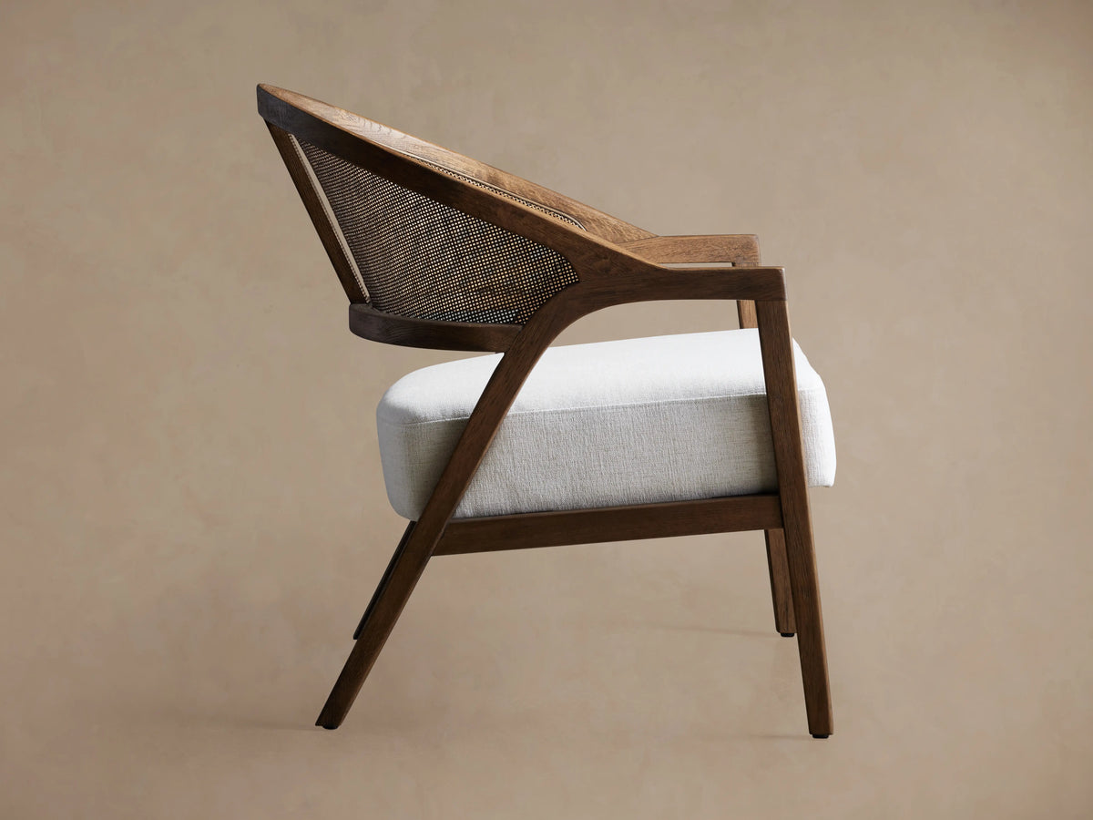 Aimee Chair: Dark oak frame with woven rattan back and white upholstered seat cushion, angled view on a neutral background.