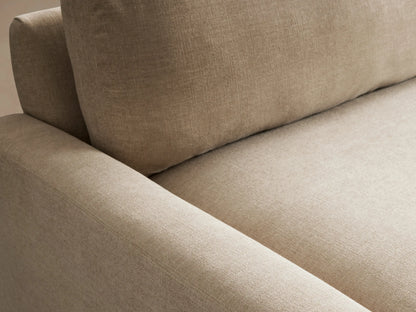 Tan Remington Sofa with two back cushions and two seat cushions, set on a wooden floor against a neutral wall background.