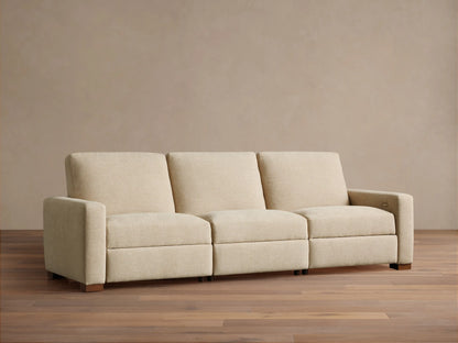 Remington Three-Piece Motion Sofa. Beige textured fabric, modular, with left arm, armless, and right arm sections, on wood floor.