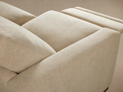 Close-up of Remington Motion Sofa's oatmeal fabric and modern silver oblong recliner control button on the side.
