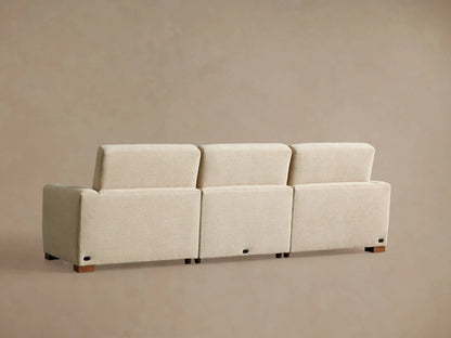 Diagonal close-up of Remington Three-Piece Motion Sofa in light beige textured fabric. Shows plush seat and back cushions from above.