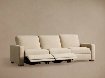Back view of a light beige Remington Three-Piece Motion Sofa, showing its three modular sections with low backrests and wooden feet.