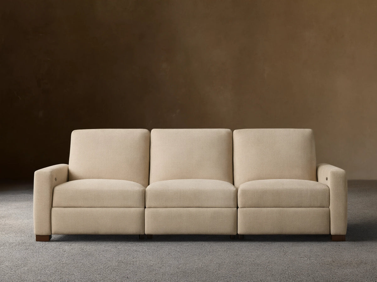 Remington Three-Piece Motion Sofa. Beige textured fabric, modular, with left arm, armless, and right arm sections, on wood floor.