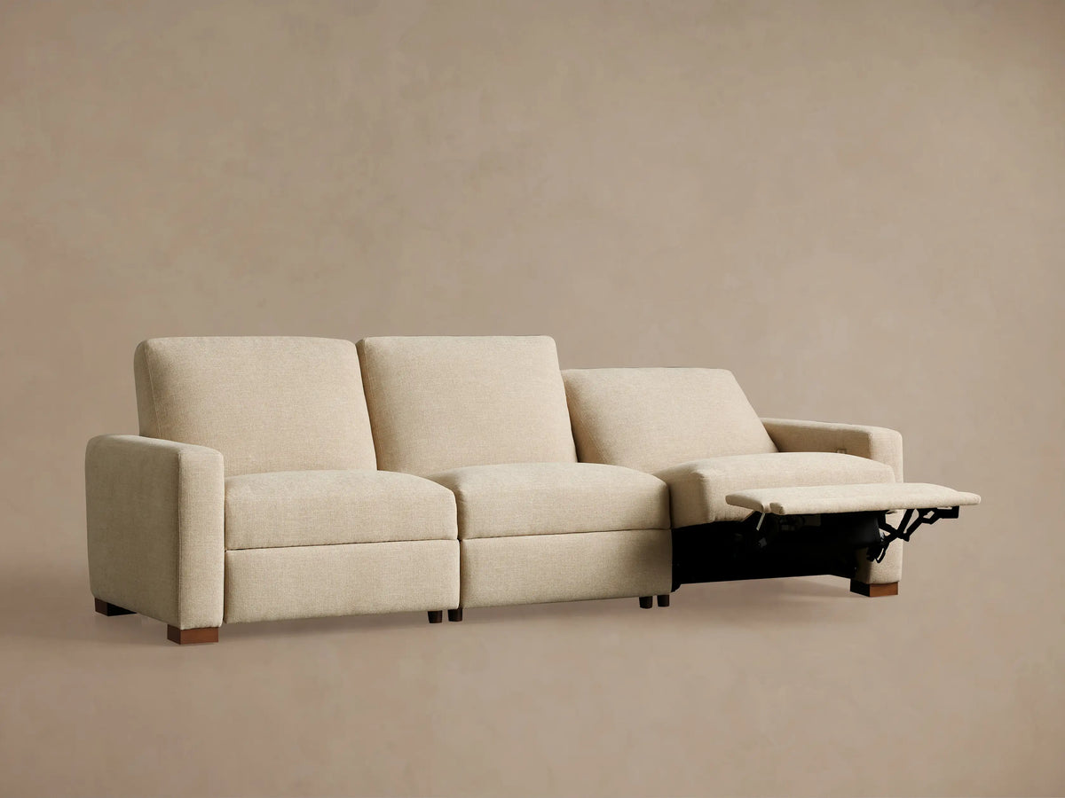 Remington Three-Piece Motion Sofa in light beige fabric. Two left seats are reclined with footrests extended, on a plain background.
