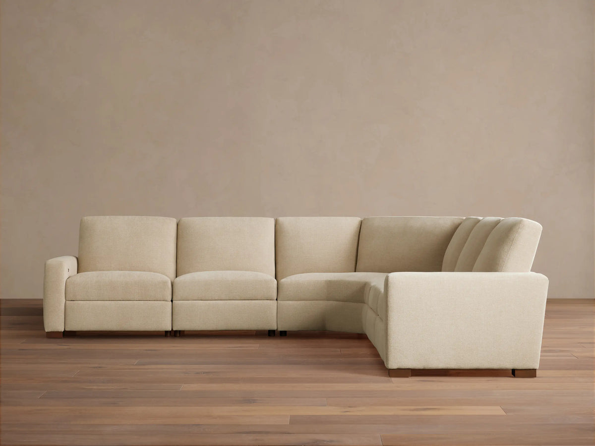 Light beige Remington Five-Piece Motion Corner Sectional, L-shaped, on wooden floor against a plain beige wall.