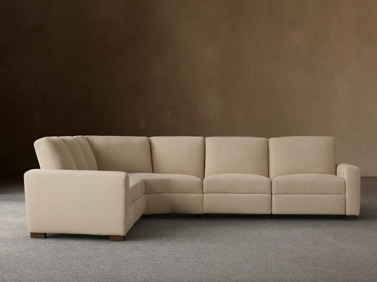 Light beige Remington Five-Piece Motion Corner Sectional, L-shaped, on wooden floor against a plain beige wall.