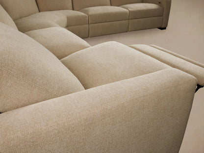 Close-up of Remington Sectional's beige textured fabric backrest, showing a modern champagne metallic recliner control.