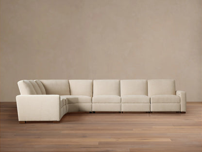 Remington Six-Piece Motion Sectional, light beige fabric, L-shaped, shown on a wooden floor against a warm beige wall.