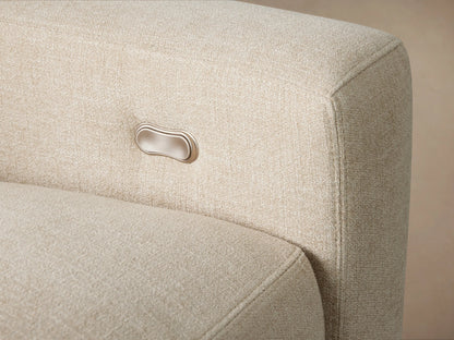 Light beige L-shaped Remington Six-Piece Motion Sectional with a corner wedge, on a wooden floor against a beige wall.