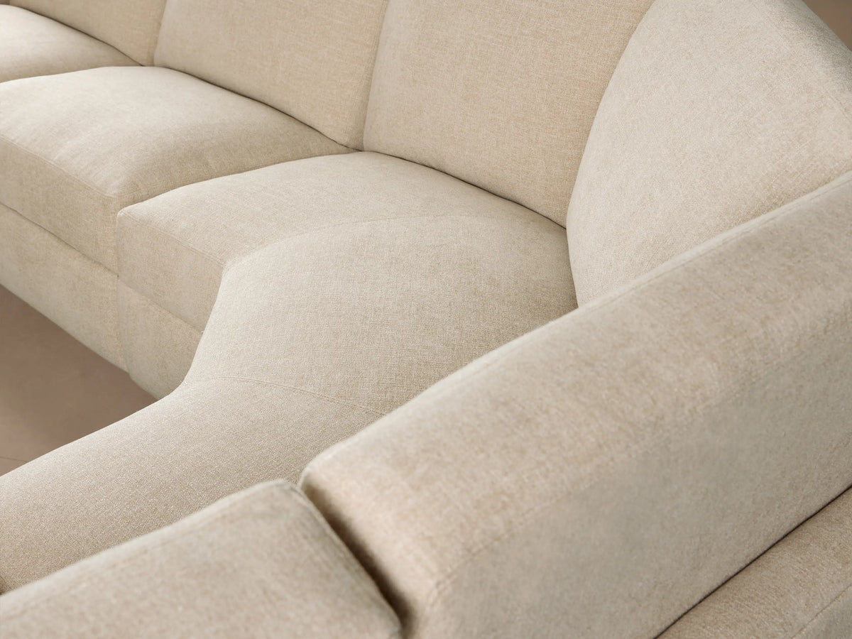 Close-up of a beige textured Remington Motion Sectional with a metallic champagne power recliner button on the side.