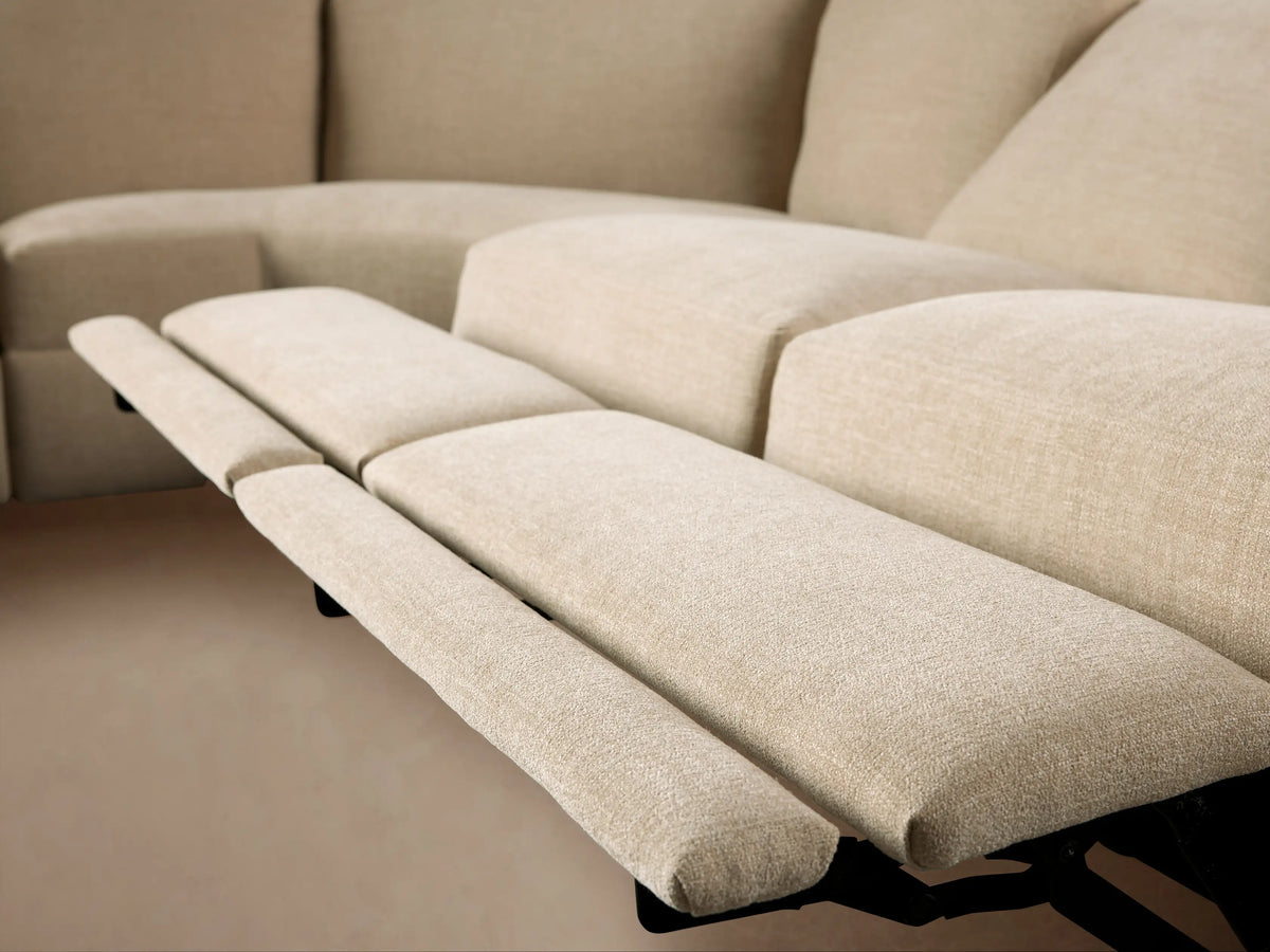 Close-up of a light beige Remington Six-Piece Motion Sectional's curved corner, showing textured fabric and plush cushions.