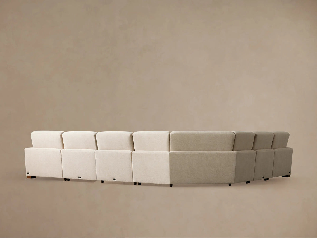 Light beige Remington Six-Piece Motion Sectional, L-shaped, with its leftmost recliner extended against a plain beige wall.