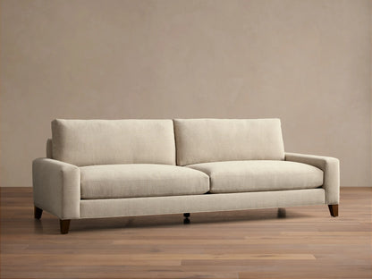 Front view of the light beige Remington Elevated Sofa with two seat cushions, two back cushions, and dark mocha-finished elevated legs.
