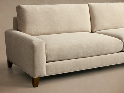 Front view of the beige Remington Elevated Sofa with two seat cushions, two back cushions, and mocha finish legs.