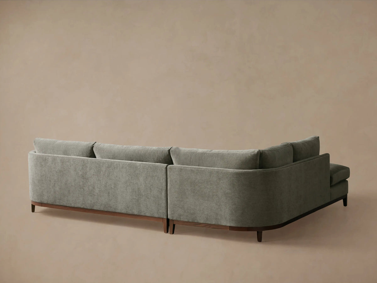 Close-up of the Bainbridge Two-Piece Bumper Sectional in textured grey fabric, with soft seat, back, and curved arm cushions.