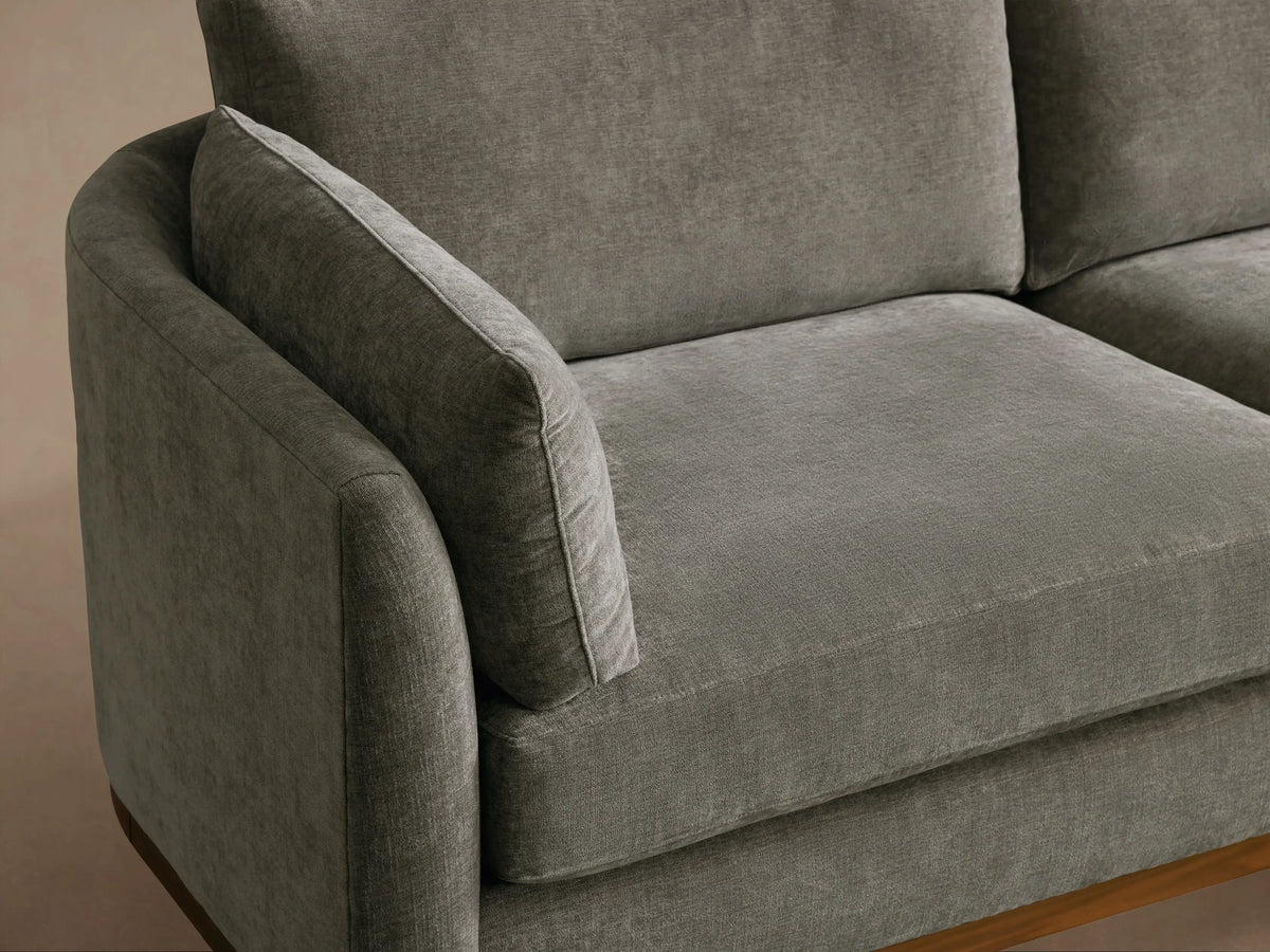 Gray Bainbridge Two-Piece Bumper Sectional, L-shaped with a right bumper chaise, visible dark wood frame and legs.