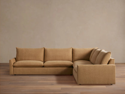 Tan-colored, L-shaped Calistoga three-piece corner sectional on a wooden floor against a neutral wall. Thick cushions and plush backrests.