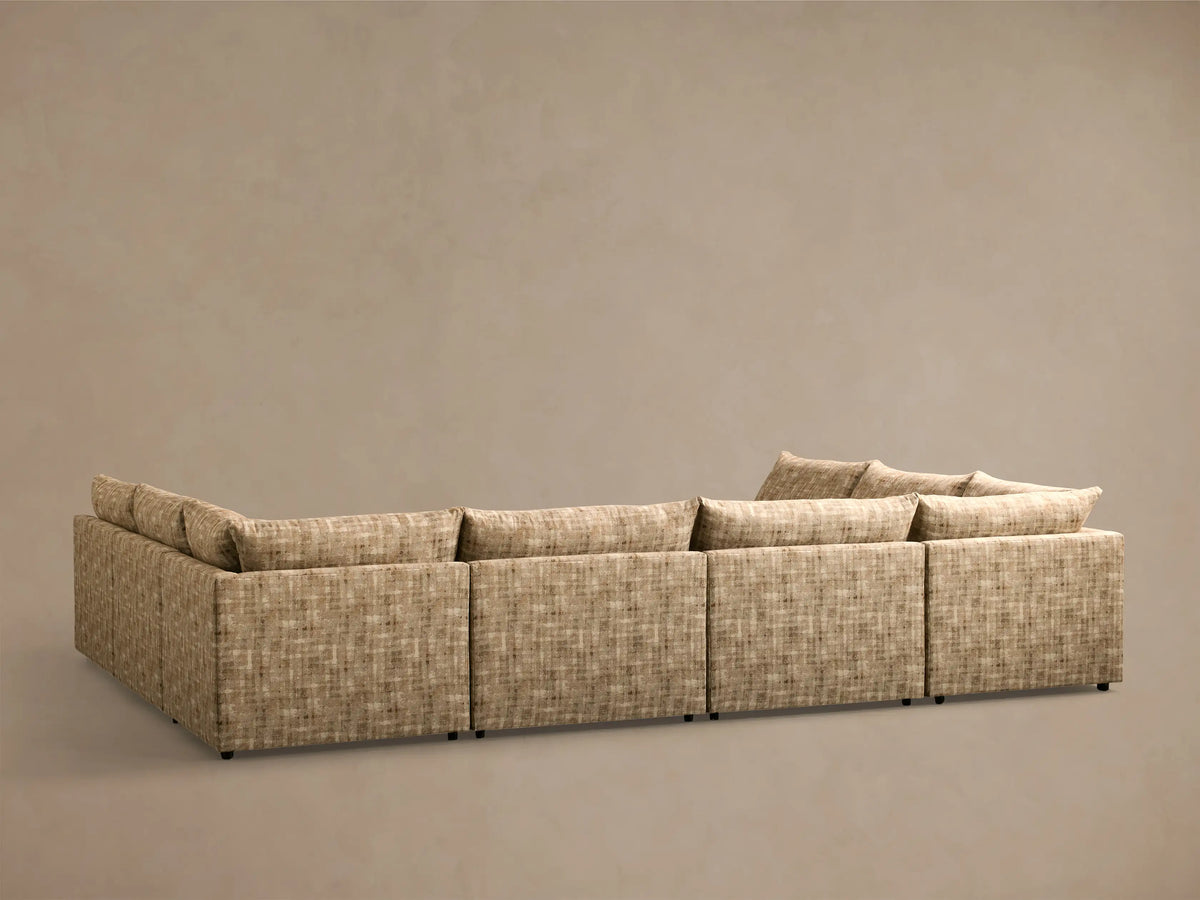 Rear view of the beige textured fabric Calistoga Eight-Piece Sectional, showing its L-shaped configuration.