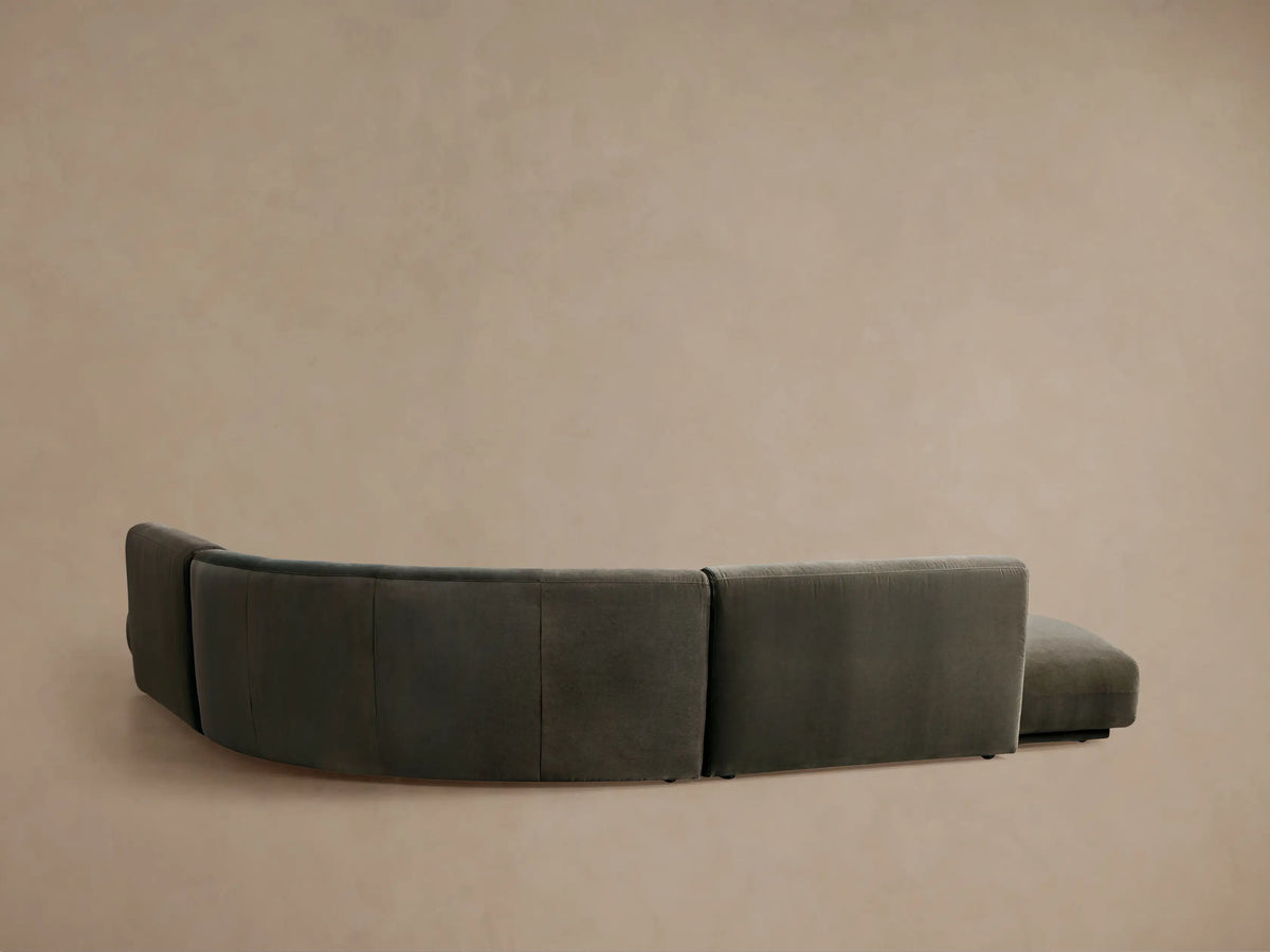 Close-up of a dark grey velvet Gianni Curved Bumper Sectional, showing its plush texture and gentle curve.